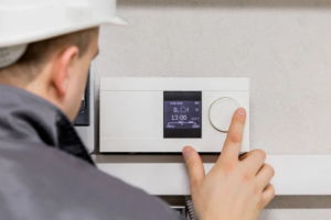 An HVAC technician checking the thermostat | Gibber Services