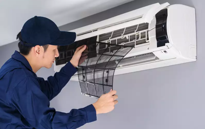 The HVAC technician replaces the air filter