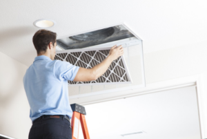 An HVAC technician cleans the air filter of the house