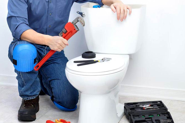 A plumber prepares to fix a clogged toilet- Bartlett, TN