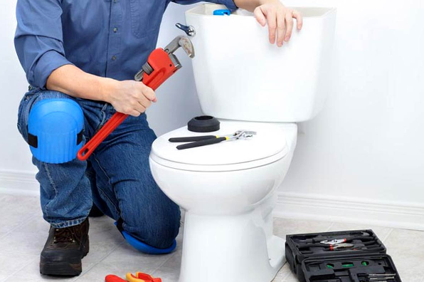A plumber prepares to fix a clogged toilet- Germantown