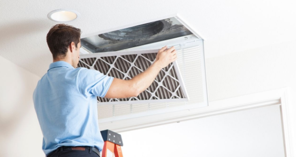 AC Unit technician cleans and inspects air purification system